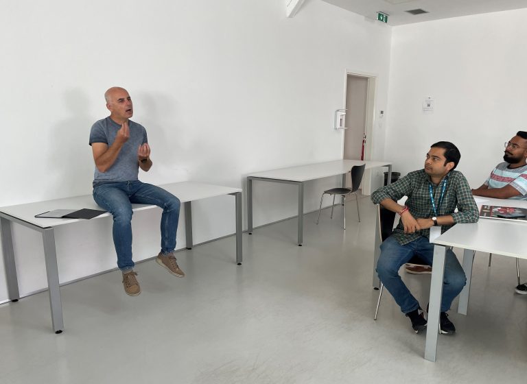 profesor sedi na mizi in razlaga studentom