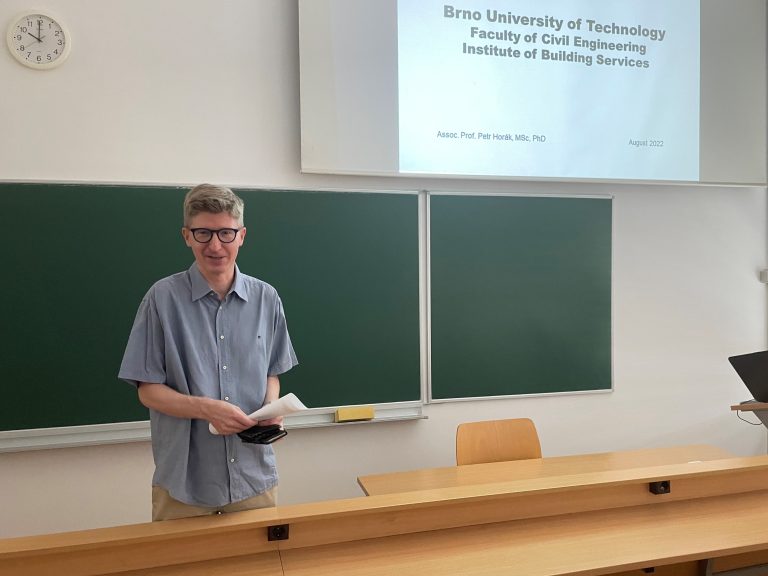 predavatelj stoji pred tablo in projekcijo