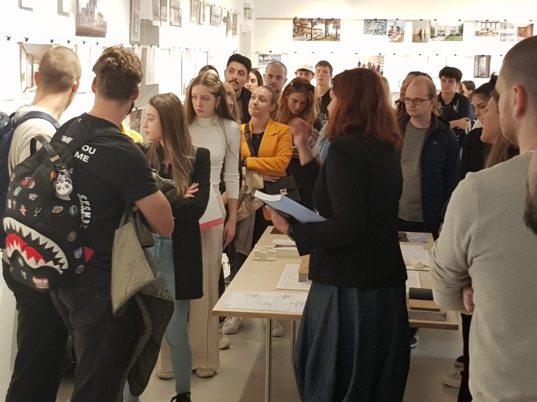 studentje stojijo ob steni in gledajo nanjo