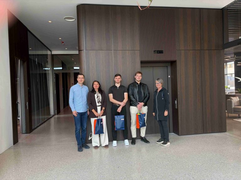 Skupinska fotografija v avli podjetja GIC GRADNJE. Z leve proti desni: dr. Rok Cajzek, dr. Mateja Držečnik, Mark Antony Frank, Evelin Pivić in dr. Tjaša Zupančič Hartner.